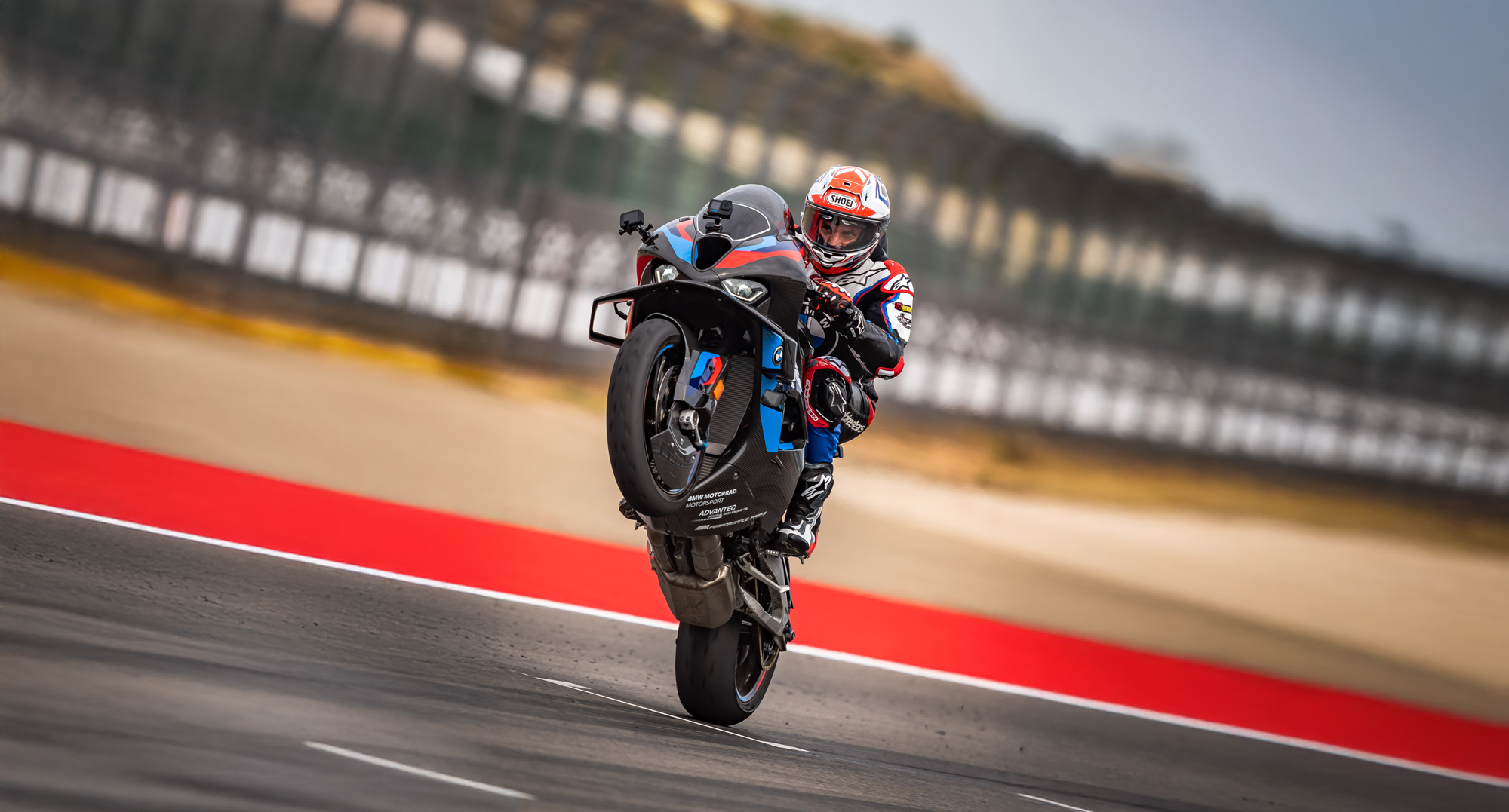 Alex Hofmann in Racing Bekleidung der auf einem Racing Motorrad um eine Kurve fährt