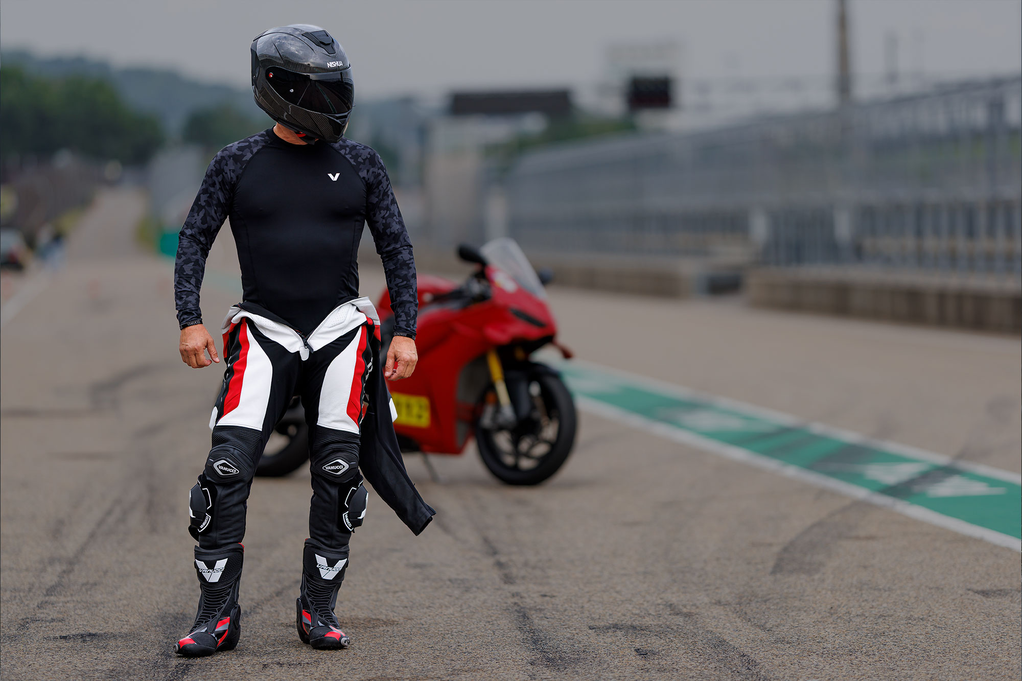 Ein Mann in Motorrad Funktionswäsche vor einer Berglandschaft