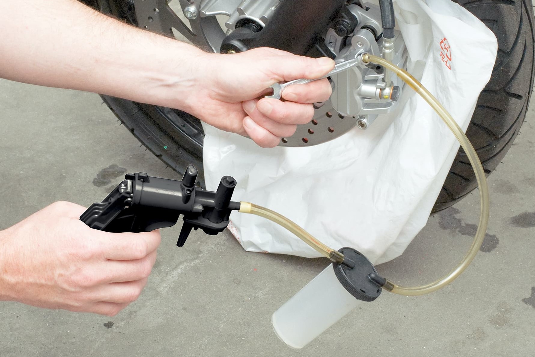 Method 2, step 6: Draw off brake fluid and air – observing the fill level in the container