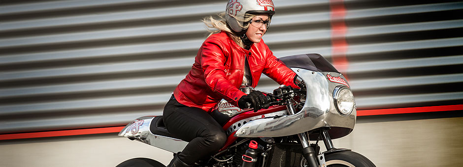 Frau in Roter Biker Jacke auf einem Retro Motorrad