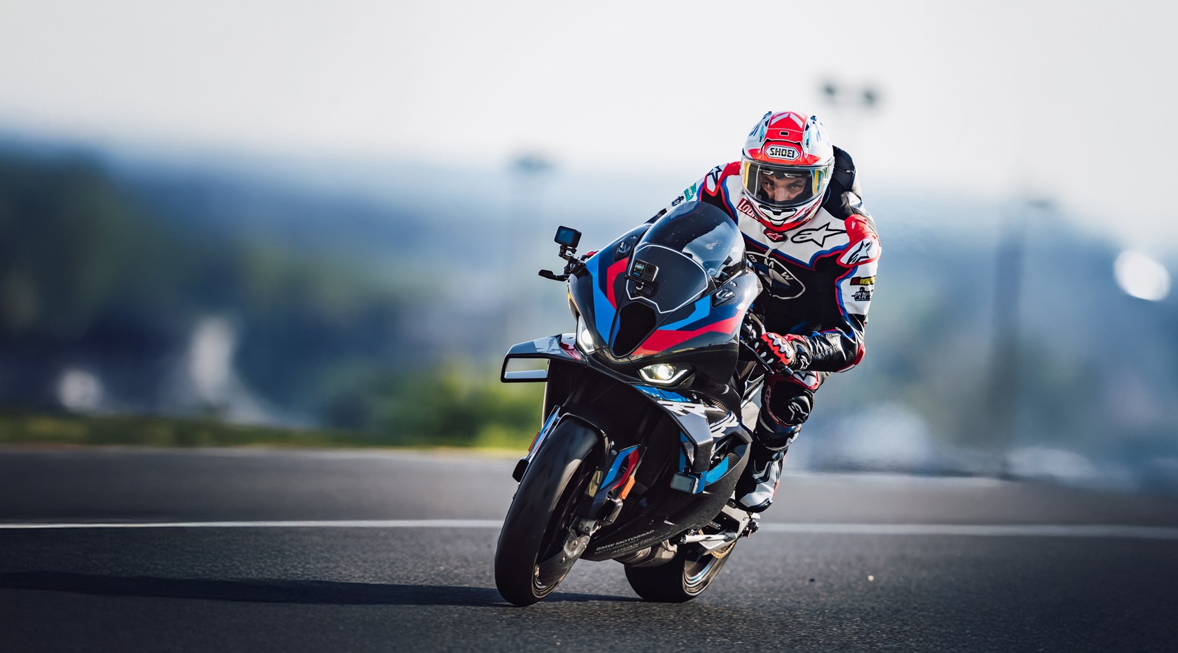 Alex Hofmann in Racing Bekleidung der auf einem Racing Motorrad um eine Kurve fährt