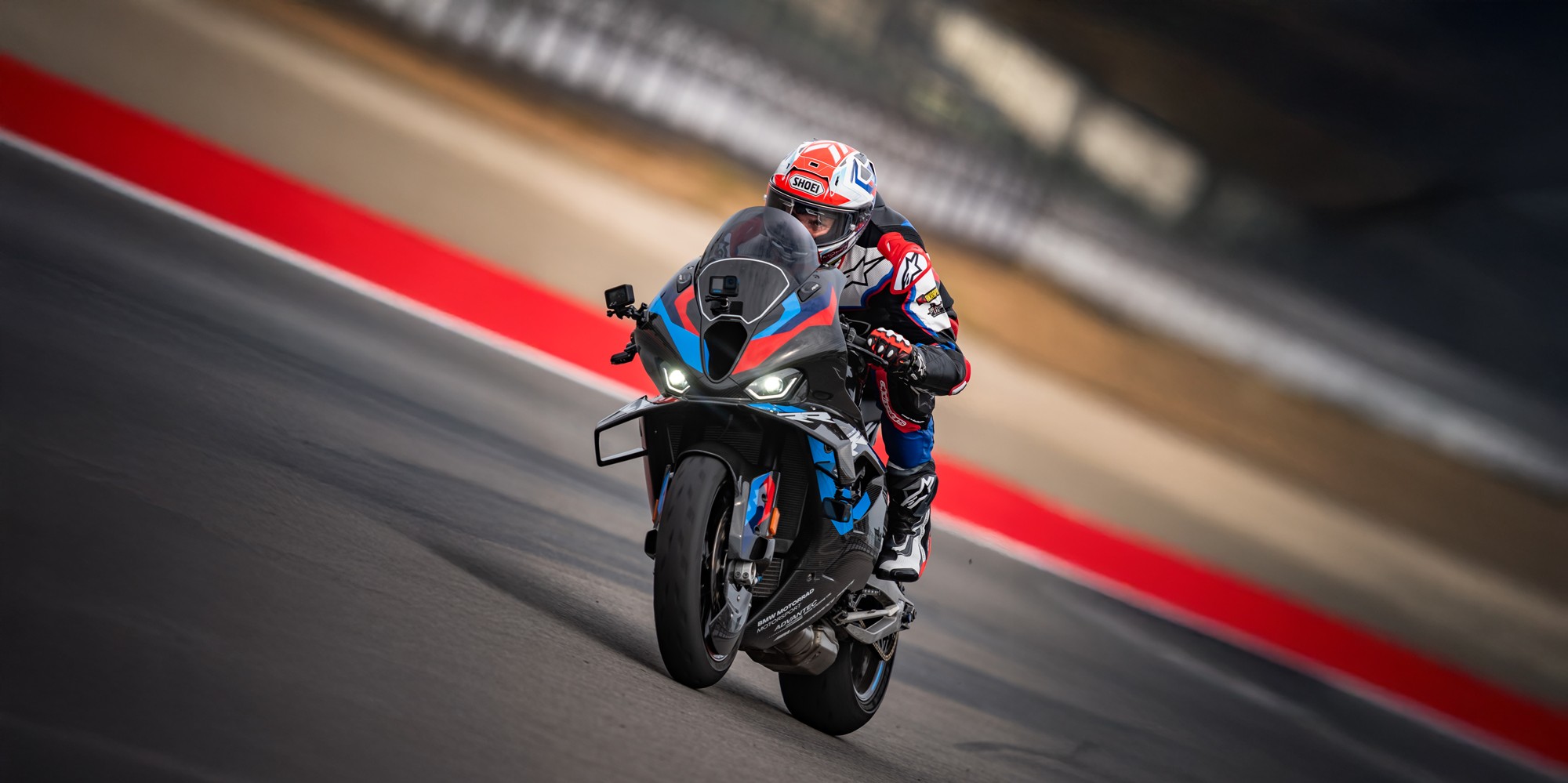 Alex Hofmann in Racing Bekleidung der auf einem Racing Motorrad der einen Wheelie macht