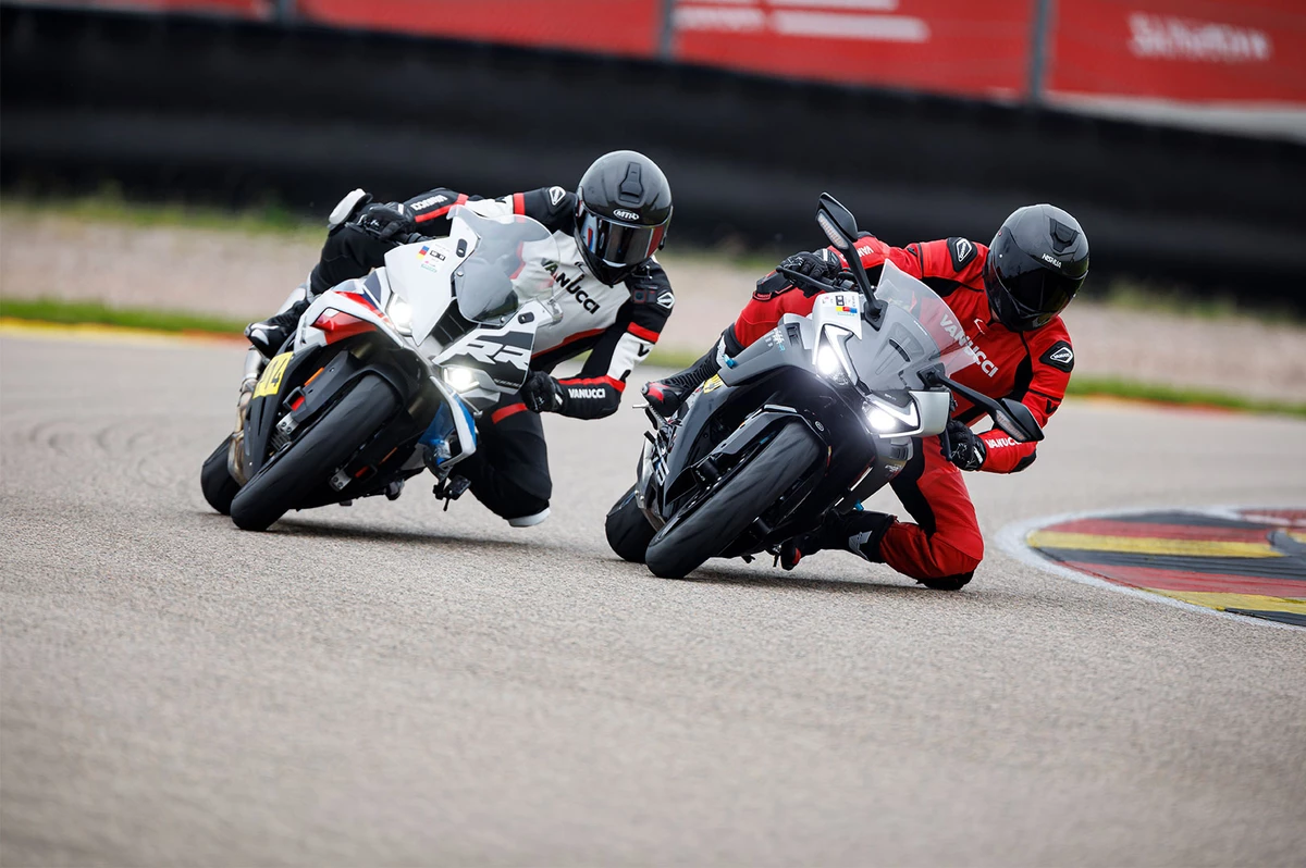 KI generiert: Das Bild zeigt zwei Motorradrennfahrer, die auf einer Rennstrecke im Wettbewerb stehen. Sie tragen Schutzausrüstung und fahren auf ihren jeweiligen Motorrädern eng nebeneinander.