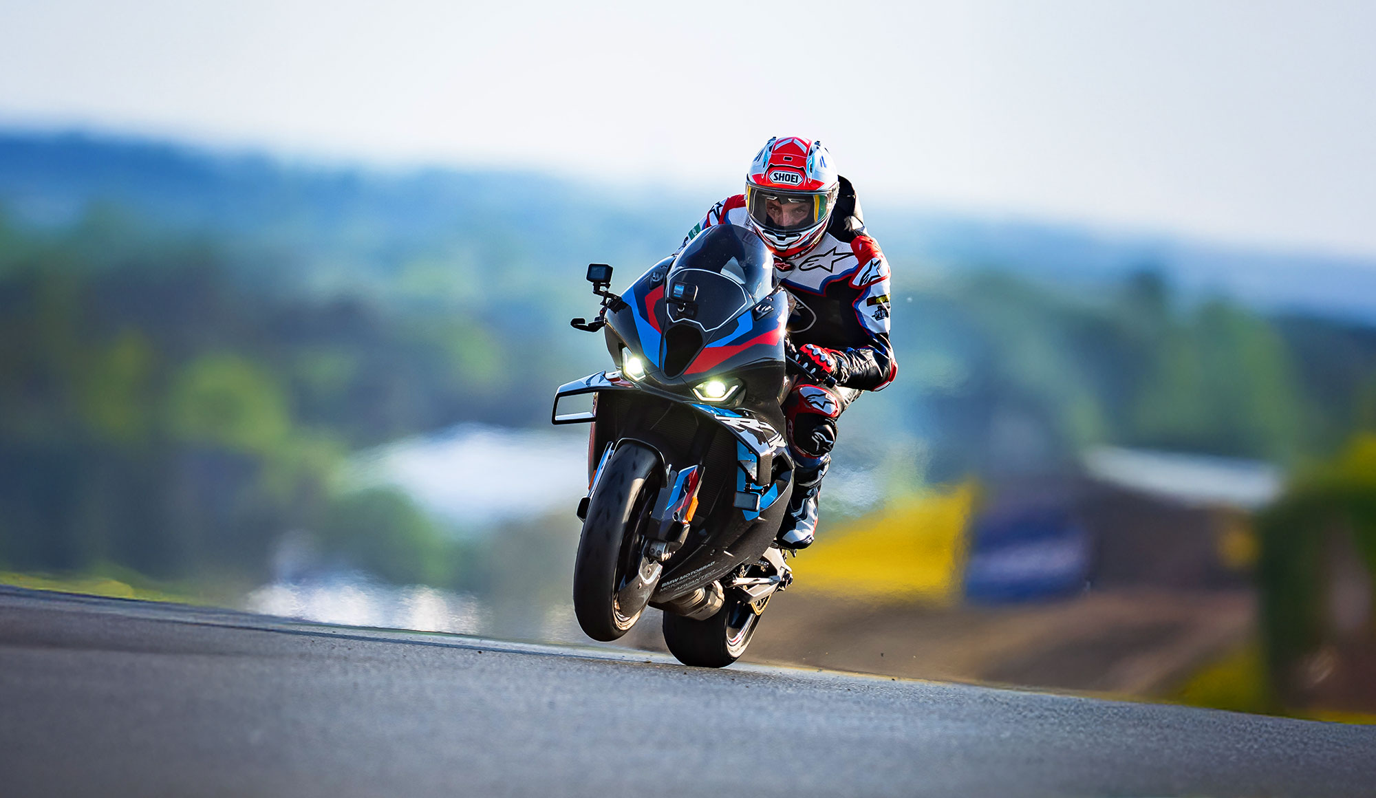 Alex Hofmann in Racing Bekleidung der auf einem Racing Motorrad um eine Kurve fährt